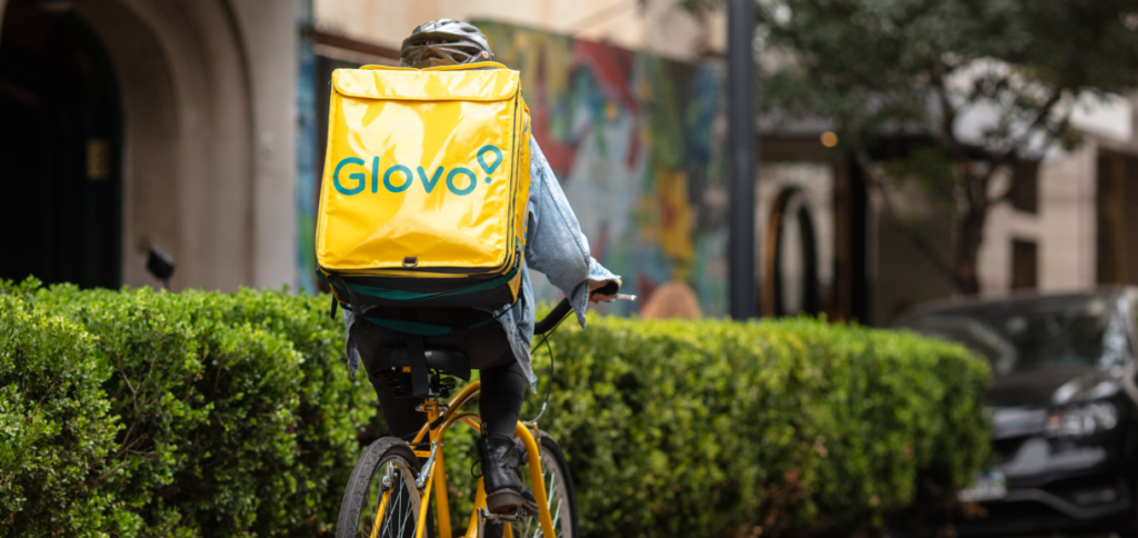A Glovo delivery rider cycling through the city