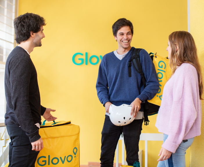 Three happy glovo employees laughing and talking
