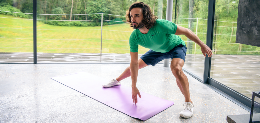 Joe Wicks doing lunges on a pink gym mat